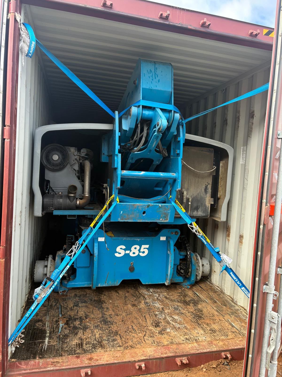 Boom Lifts packing – Genie S85 boom lift strapped in a container