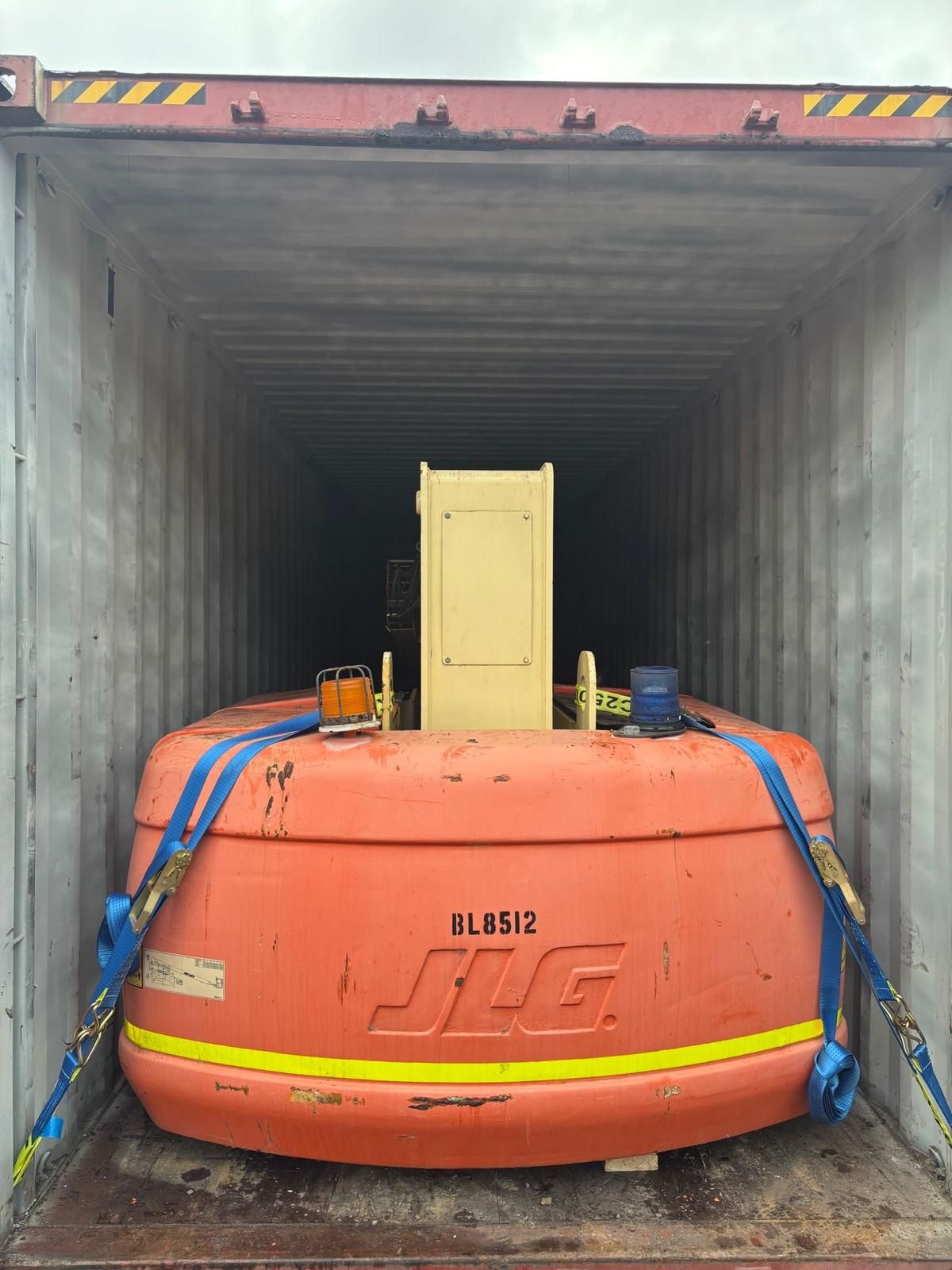 Boom Lifts packing – JLG 860SJ boom lift strapped in a container